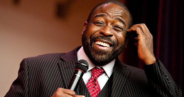 Les Brown holding a microphone laughing